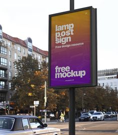 a large sign is on the side of the road near some parked cars and buildings