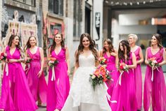 a bride and her bridesmaids in bright pink dresses