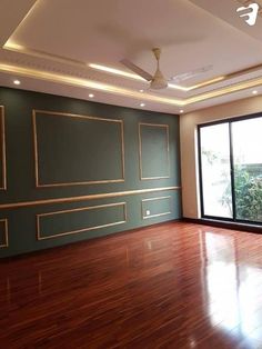 an empty room with wood flooring and green painted walls, along with large sliding glass doors