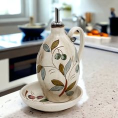 a ceramic tea pot and saucer sitting on a counter