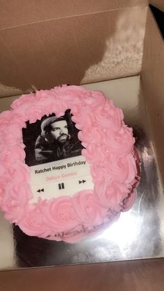 a pink cake in a box with a photo on it