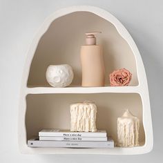 two white shelves with candles, vases and books