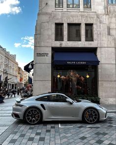 a silver sports car parked in front of a building