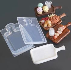 three plastic trays with different types of food in them on a black table top