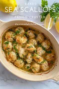 baked sea scallops with parsley in a white bowl on a marble counter