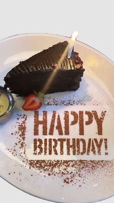 a piece of chocolate cake on a plate with the words happy birthday