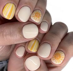 a woman's hands with yellow and white nail polish