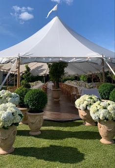 a large white tent set up with tables and chairs