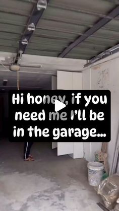 a man standing in an empty garage next to a wall with the words hi home, if you need me i'll be in the garage