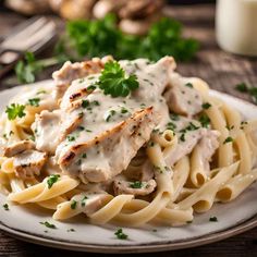 a plate of chicken alfredo with mushrooms and parsley