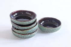 a stack of ceramic bowls sitting next to each other on top of a white table