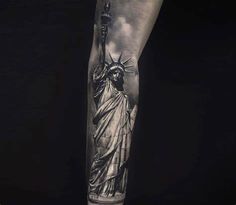 a man's leg with a statue of liberty tattoo on the side of his arm