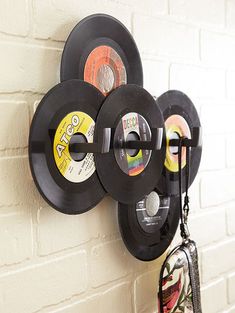 three black records are hanging on the wall next to a purse and wallet bag,