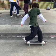 a young man riding a skateboard down a sidewalk