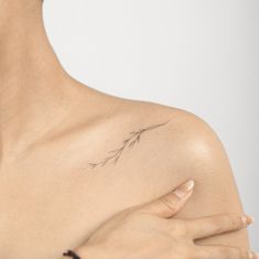 a woman's shoulder with a small tattoo on it