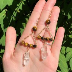 a person holding some kind of necklace in their hand with beads and stones on it