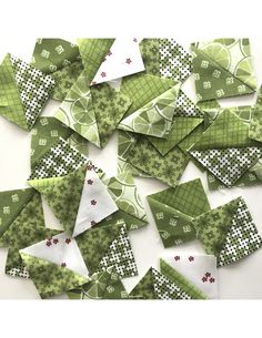 several pieces of green fabric with white and red designs