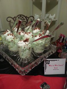 there are many desserts on the glass plate and in the tray is spoons