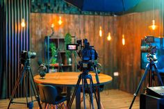 a camera and tripod set up in front of a table