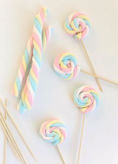 colorful lollipops and candy sticks on a white surface