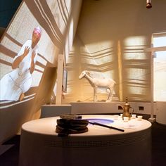 an exhibit room with various items on the table and in front of it is a horse statue