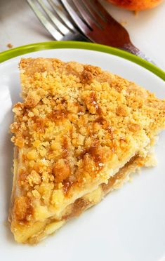 a piece of pie sitting on top of a white plate next to a green fork