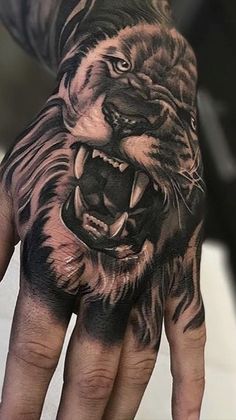 a man's hand with a tattoo of a tiger on it and his face