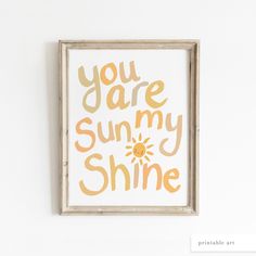 an art print with the words you are my sunshine written in orange and yellow on a white wall