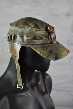 Postapoc Cap - Military Style Cap - Wasteland LARP Headpiece - Army Green Cap - LARP Accessories - Post Apocalyptic Hat - Handmade Headwear A unique post-apocalyptic styled cap. An olive green base, decorated with leather straps and stylish ear flaps. It's a unique costume piece that will add a spark of life to any military-style outfit! Finished with professional paintwork for a distressed effect, it has a very lifelike feel of a worn down headpiece. It's a one size product. More apocalyptic clothing: https://etsy.me/3Z2OHJ5 More accessories: https://etsy.me/2jskDVG MY ETSY SHOP: https://www.etsy.com/shop/WastedCouture Wear if you dare! --------------------------------------------------------------------- Wasted - Wasted Couture - WastedCouture Military Style Outfits, Larp Accessories, Post Apocalyptic Outfit, Apocalyptic Clothing, Army Clothes, Apocalyptic Fashion, Green Cap, Unique Costumes, Concept Clothing