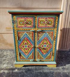 an ornate painted wooden cabinet on the sidewalk