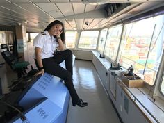 a woman sitting on the edge of a boat talking on a cell phone and smiling