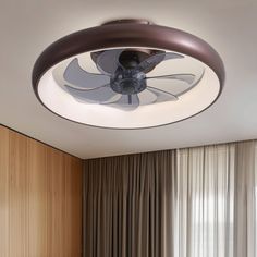 a ceiling fan is mounted on the wall above a bed in a room with wood paneling