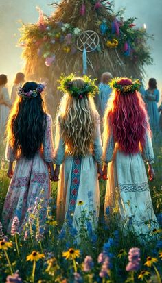 three girls with long hair standing in the middle of a field looking at an elaborate structure