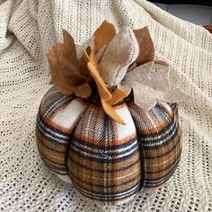 two decorative pumpkins sitting on top of a white blanket