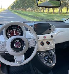 the interior of a small car with steering wheel and dash board, along with dashboard controls