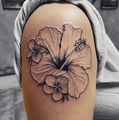 a black and white photo of a flower on the back of a woman's shoulder