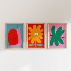 three colorful paintings hang on the wall next to each other