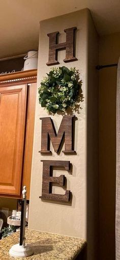 the word home is made out of wood and has a wreath on top of it