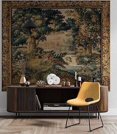 a room with a large tapestry on the wall and a yellow chair in front of it