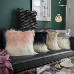 a living room filled with lots of furniture and pillows on top of a couch next to a coffee table