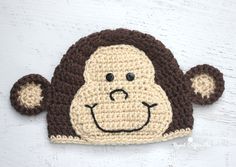 a crocheted monkey hat with two ears on it's head is shown