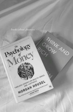 two books sitting on top of a bed next to each other in black and white