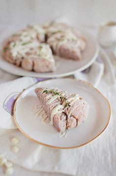 two plates with food on them sitting on a table next to cups and saucers