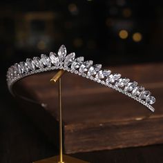 a diamond tiara on a stand in front of a wooden table