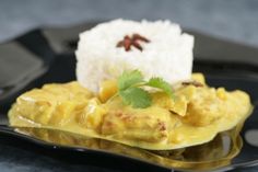 a black plate topped with rice and curry