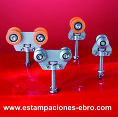 four metal casteors with orange wheels on a red background