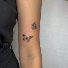 two butterflies tattoo on the left forearm and right arm, with one butterfly flying away from the other