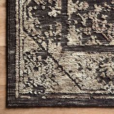 a black and white rug on top of a wooden floor