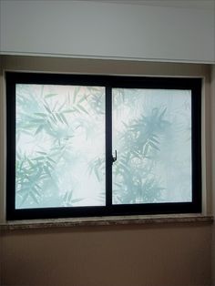 an open window in a room with plants on the outside and light coming through it