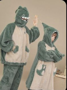 two people in frog costumes standing next to each other, one holding a toothbrush